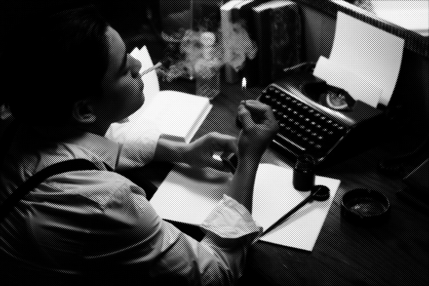 A dark, distorted, halftone image of a man smoking and holding a lit match over some papers and a typewriter.